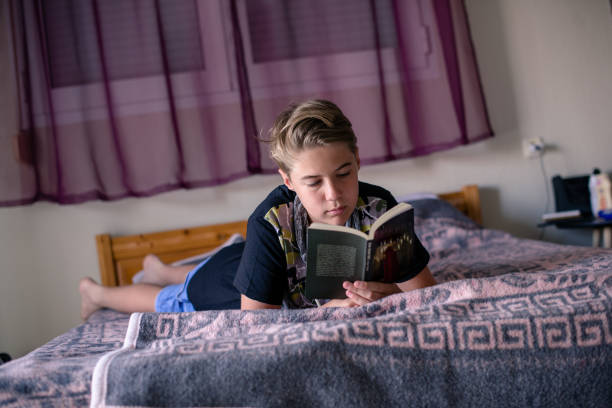 istock Teenage boy is reading a book 1262733783