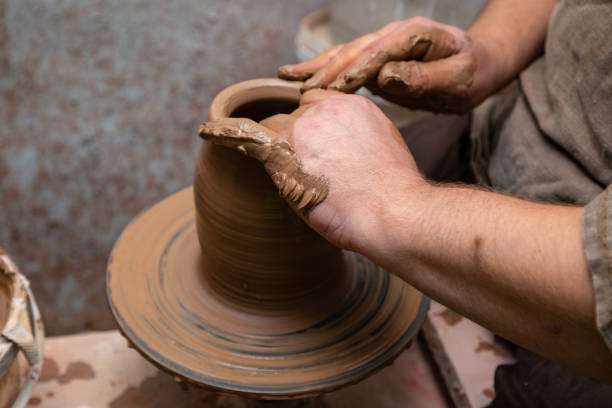 istock Creating a pot of clay close-up. Hands making products from clay. Potter at work. 1262733970