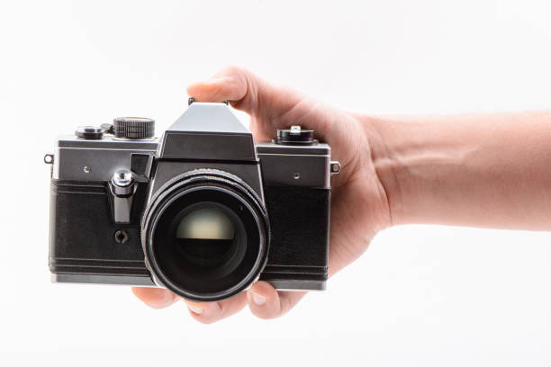istock Hand holding a retro-style camera on white background 1262735162