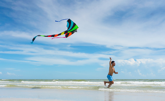 Flying a kite on empty beach in Florida