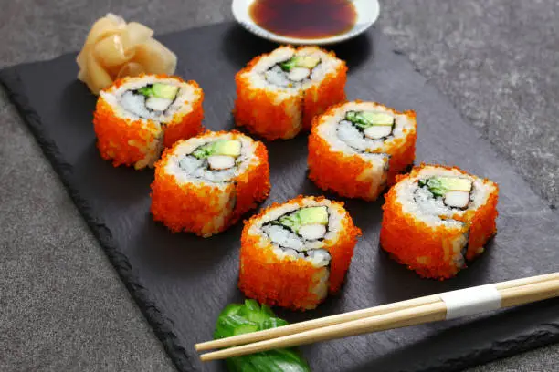 homemade california rolls, mad of crab sticks, avocado, cucumber inside. tobiko(flying fish roe) outside.