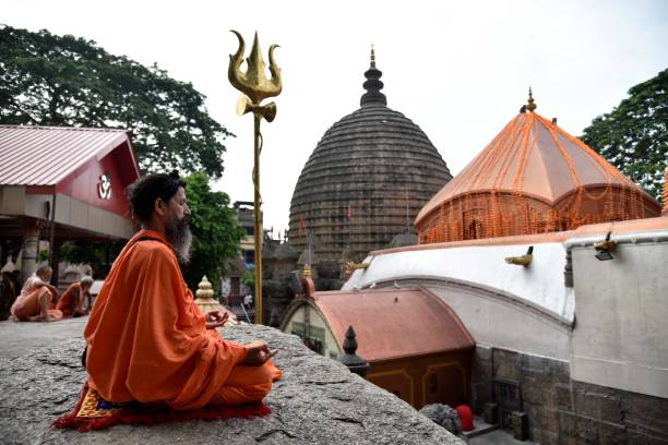 Hindu holy men or monk perform yoga Guwahati, Assam, India. 21 June 2019. Hindu holy men or Hindu monk perform yoga during Ambubachi Mela to mark International Yoga Day at Kamakhya Temple in Guwahati. The International Day of Yoga has been celebrated annually on 21 June. guwahati stock pictures, royalty-free photos & images