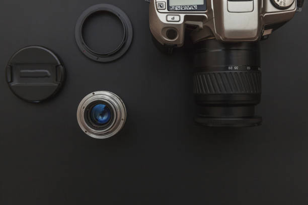istock Photographer workplace with dslr camera system and lens on dark black table background. Hobby travel photography concept. Flat lay top view copy space 1262746317
