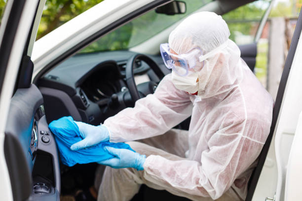 istock Disinfectant worker character in protective mask and suit sprays bacterial or virus in a car. 1262748706