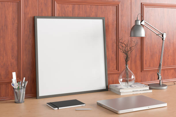 istock Square poster frame mockup on the wooden table of home studio workspace with classic style decoration wall. Side view, clipping path around poster picture. 1262749636