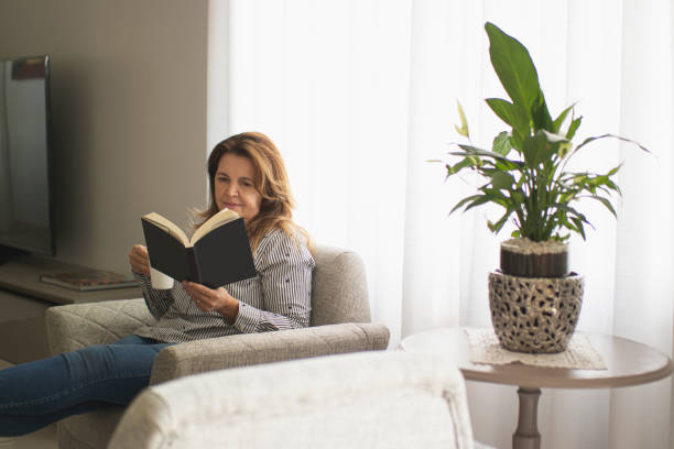 istock Woman reading a book at home. 1262757156