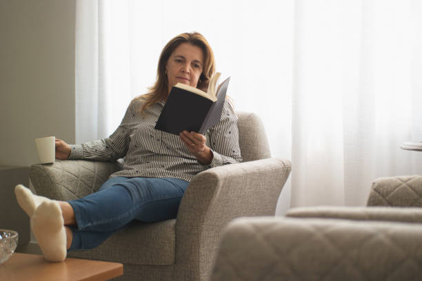 istock Woman reading a book at home. 1262757184