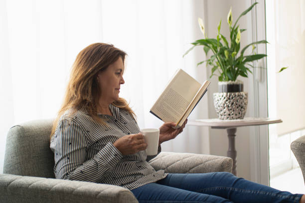 istock Woman reading a book at home. 1262757300