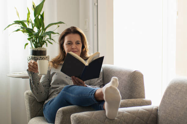 istock Woman reading a book at home. 1262757309