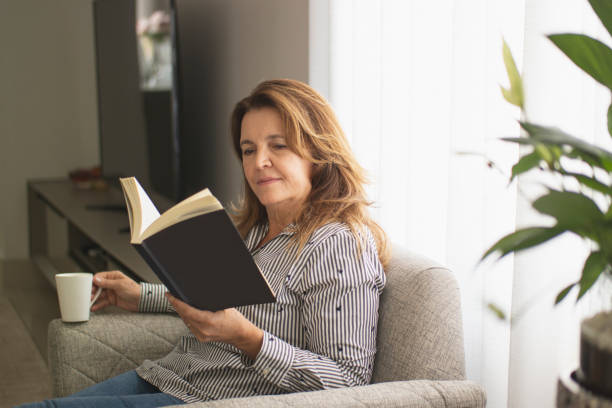 istock Woman reading a book at home. 1262757430