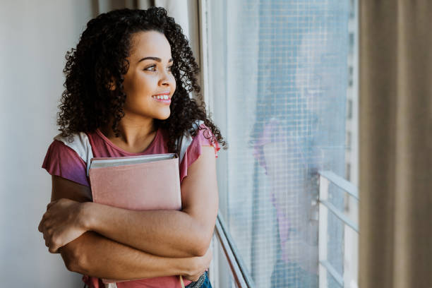 istock Woman embraced with bible in window light 1262760626