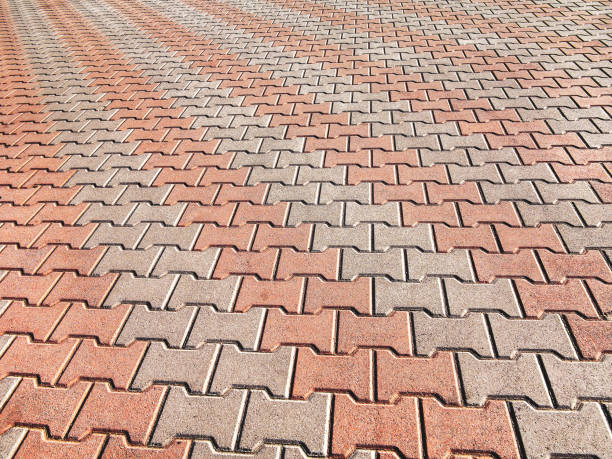 istock Decorative colorful sidewalk pavement. Tiled floor with grey tiles crossed by a diagonal double stripe of red tiles viewed at a low angle, full frame background pattern 1262763580