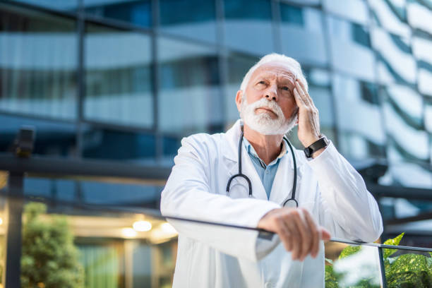 istock Stressed senior male doctor having a headache. 1262766011