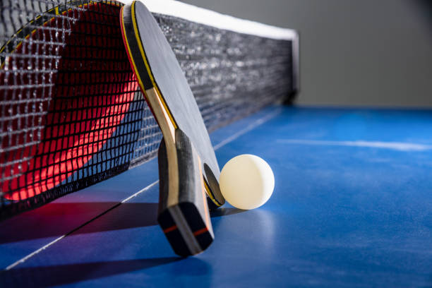 istock Closeup red table tennis paddle white ball and a net 1262768813