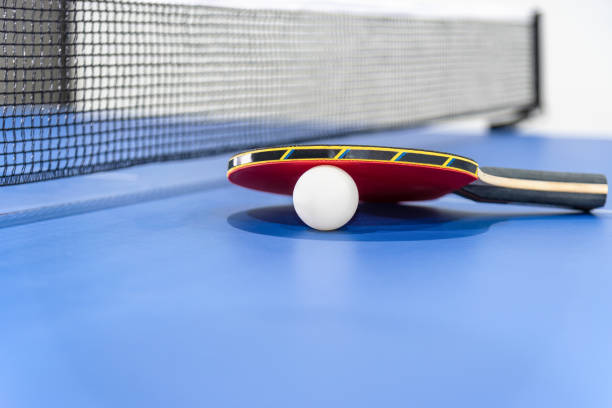 istock Closeup red table tennis paddle white ball and a net 1262768818
