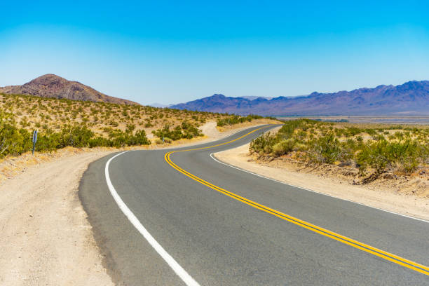 curved road in the mojave desert - desert road fotos imagens e fotografias de stock