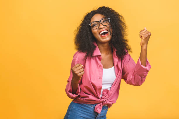 happy winner! young african american black woman isolated on yellow background giving a thumbs up gesture. - thumbs up business people isolated imagens e fotografias de stock