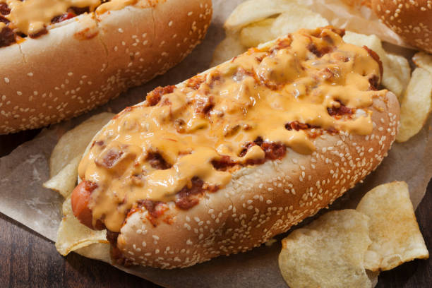 chili dog with cheese sauce and potato chips - sesame bun american culture cheddar imagens e fotografias de stock