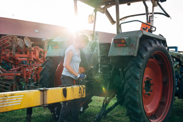 istock female farmer hangs a trailer on the tractor 1262790592