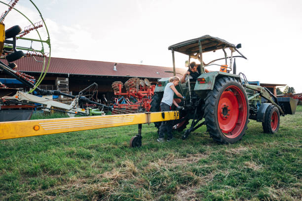 profession agricole: deux agriculteurs réparent une remorque sur un tracteur - vehicle trailer flash photos et images de collection