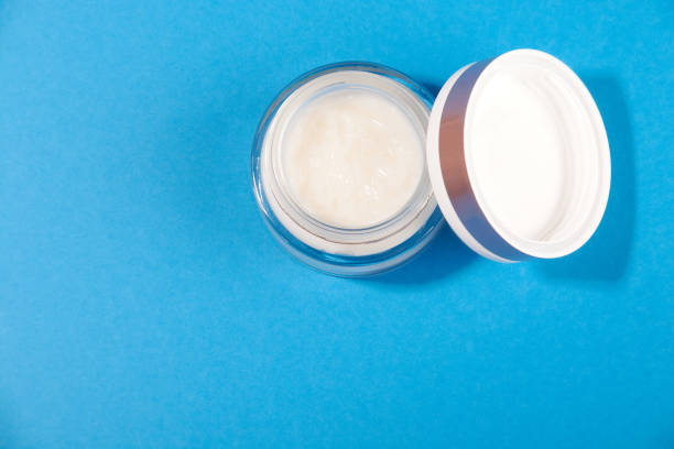 istock white cosmetic cream in a jar on a blue background 1262790887