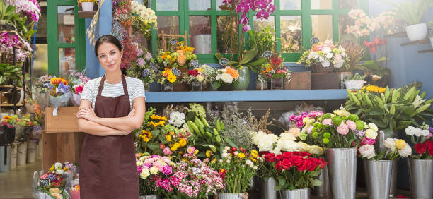スタートアップ成功した中小企業起業家オーナーアジアの女性は花屋で花を持って立っています。白人少女成功したオーナー環境フレンドリーコンセプトバナーの肖像 - spring happiness women latin american and hispanic ethnicity ストックフォトと画像