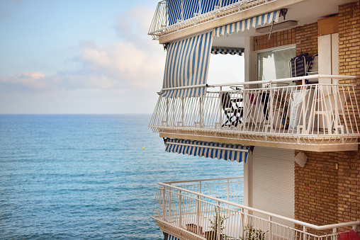 Modern brick house, balcony close-up. Panoramic view of the Mediterranean sea. Alicante, Spain. Vacations, travel destinations, cruise, recreation, hotel, resort, real estate development themes