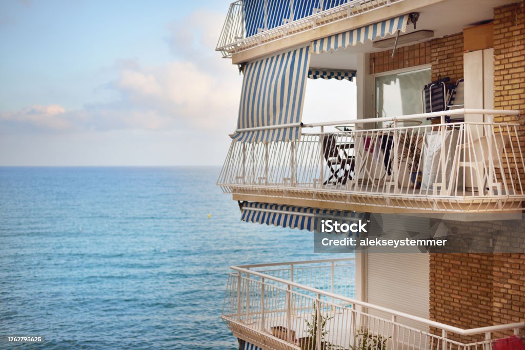 Modern brick house, balcony close-up. Panoramic view of the Mediterranean sea. Alicante, Spain. Vacations, travel destinations, cruise, recreation, hotel, resort, real estate development themes Beach Stock Photo