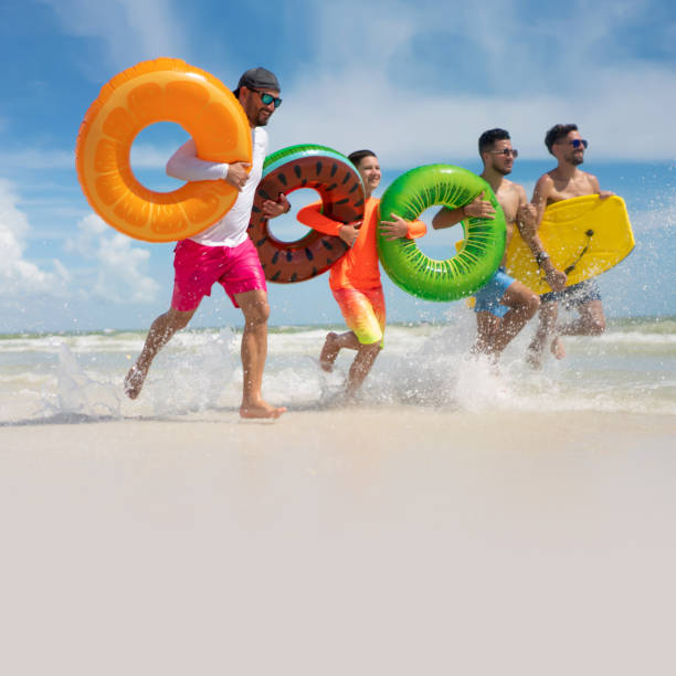 Hispanic guys with inflatable ring tubes on a beach in Miami