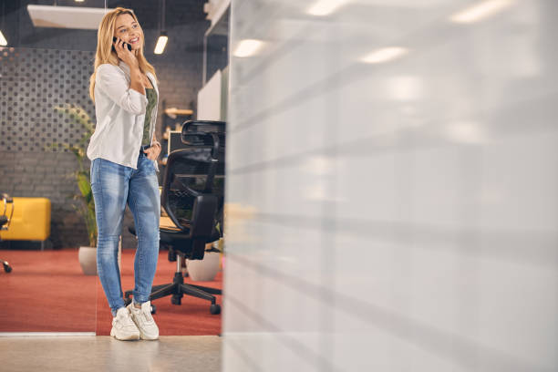 istock Cheerful young woman having phone conversation in office 1262805273