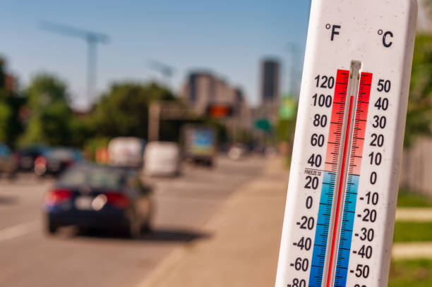 Thermometer in front of cars and traffic during heatwave stock photo