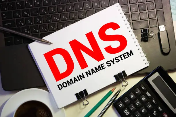DNS- Domain Name System written in notebook on wooden background