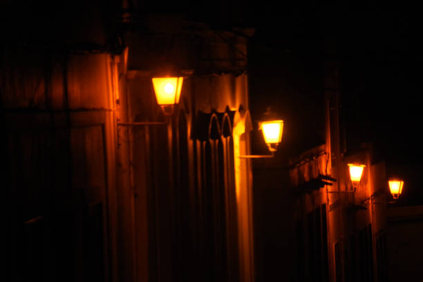 istock Bulbs glowing in a darkness street. 1262819102