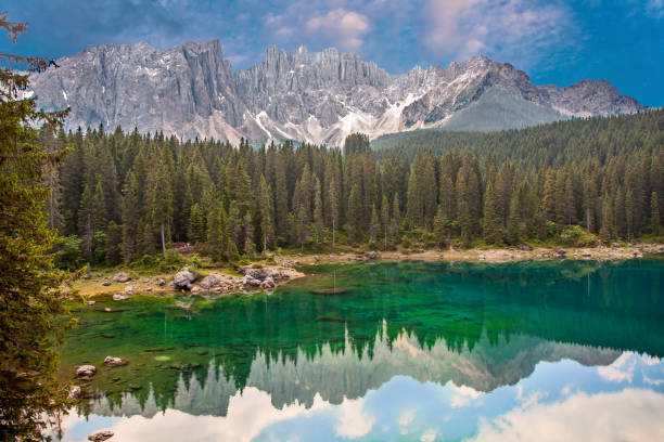 jezioro carezza alpejskie jezioro otoczone wysokim lasem sosnowym w dolomitach z widokiem na pasmo górskie rosengarten w południowym tyrolu, włochy - latemar mountain range zdjęcia i obrazy z banku zdjęć