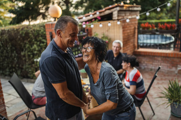 istock Happy senior couple spending time with friends and dancing in front yard 1262822772