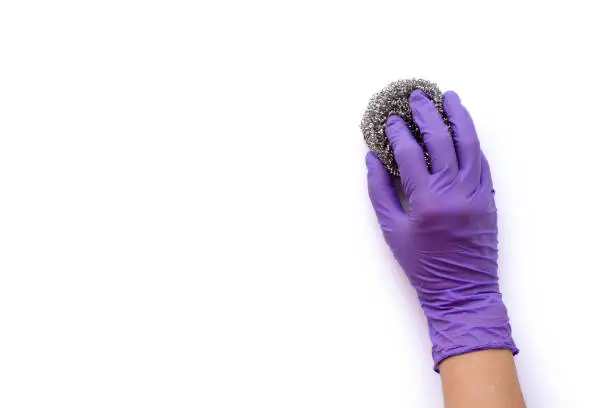 Closeup hand with rubber glove holding steel wool ( scourer pad ) for cleaning scrub isolated on white background with clipping path.