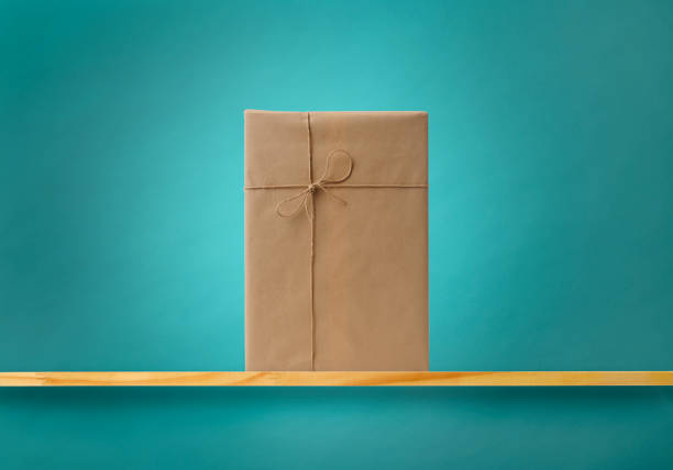 Gift box on wooden shelf against blue wall with copy space.