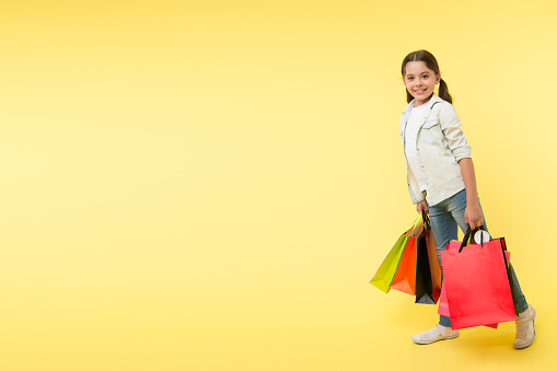 shopping day. shopping day with happy child. smiling little girl on shopping day. girl with packages after shopping day, copy space