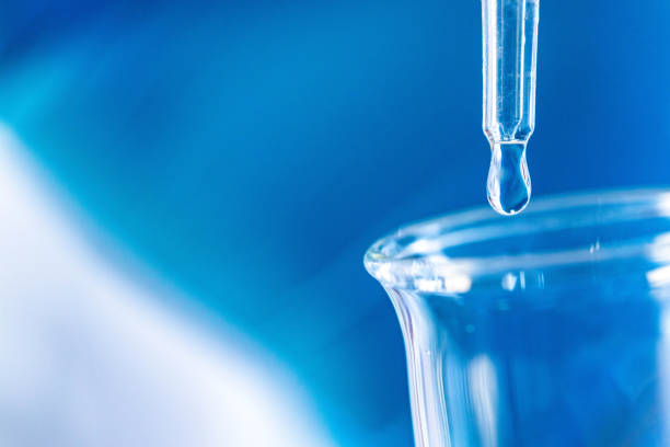 Young female chemist in formal wear conducting scientific experiment using chemicals in a laboratory.