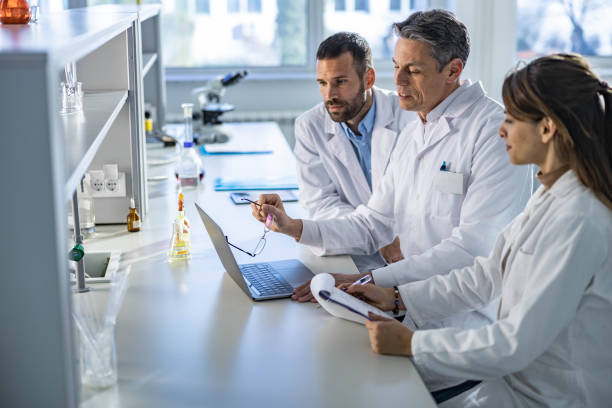 istock Team of scientists cooperating while working on laptop in laboratory. 1262841461