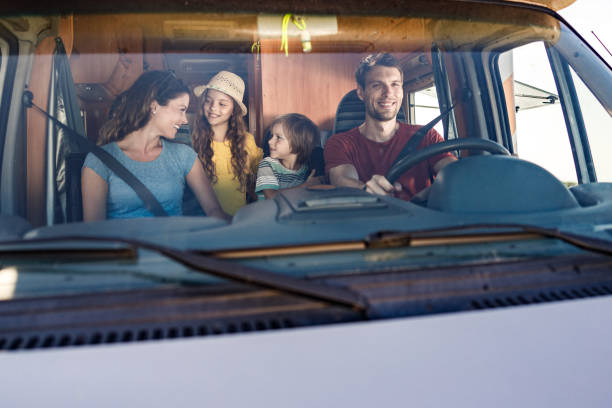 istock Happy family talking while driving inside of a camp trailer. 1262845725