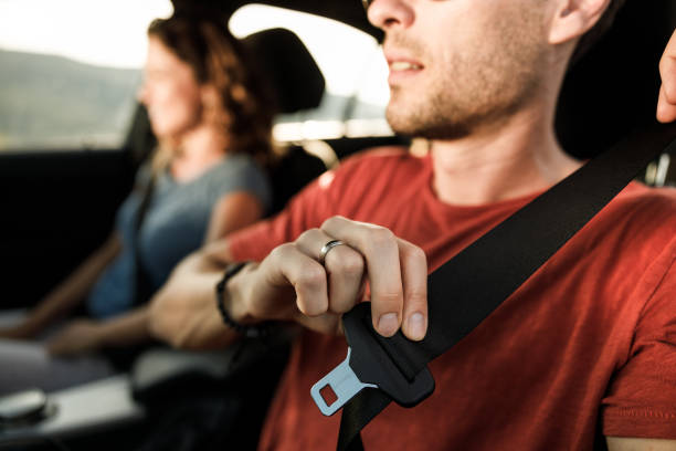 fermez-vous vers le haut de la ceinture de sécurité de fixation dans une voiture. - fastening photos et images de collection