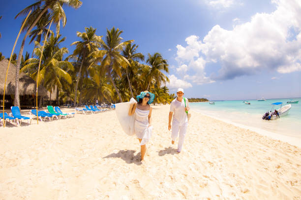 istock tourists walk through empty sandy sea beach. 1262846472