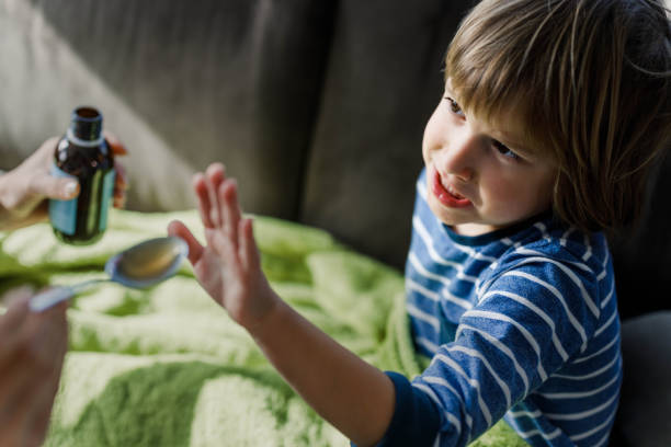 istock Angry little boy refusing to drink medical syrup at home. 1262847907