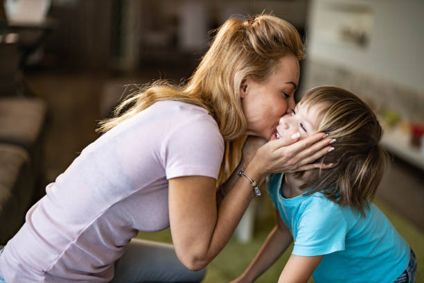 istock Affectionate single mother kissing her small son at home. 1262849083