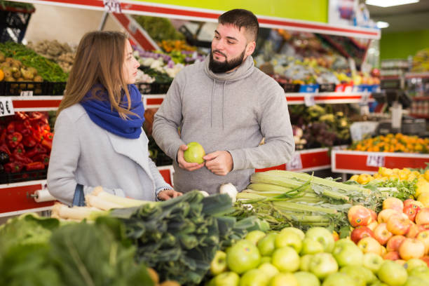 istock Glad couple choosing vegetables in grocery shop 1262849087