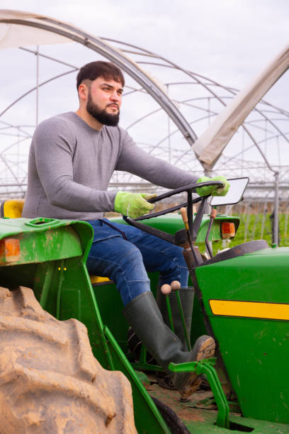 istock Young farmer working on farm tractor 1262853025