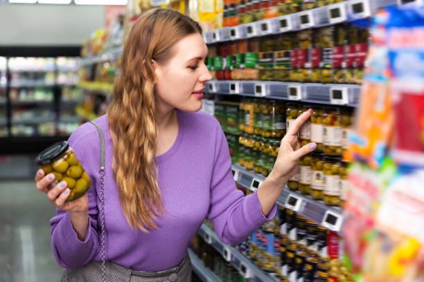 istock Ordinary girl choosing spanish green olives 1262853241