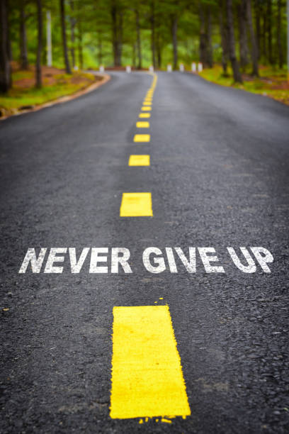 istock Never give up word on asphalt road surface with marking lines 1262853274