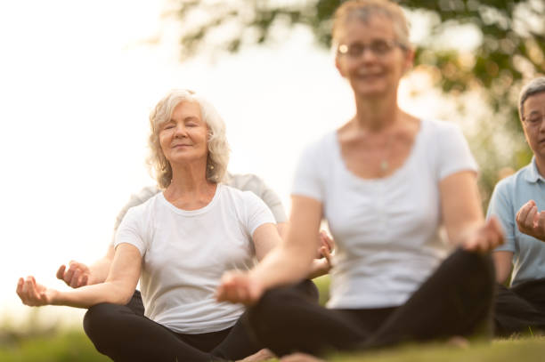 istock Seniors meditate in group outdoors 1262854850